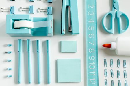 Bright blue school supplies arranged in rows on white backgroundの写真素材