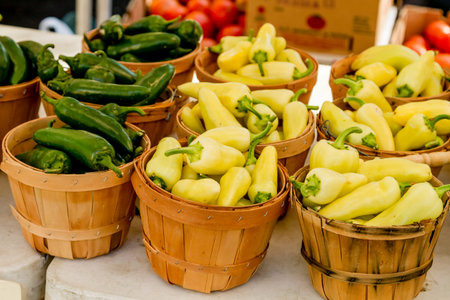 Variety of peppers in brown bushel baskets for sale at local farmers market