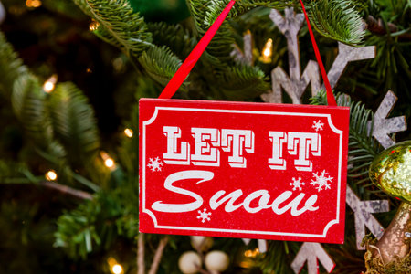 Let It Snow sign ornament hanging on Christmas tree