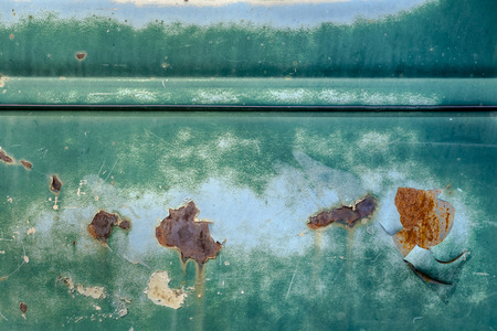 Background of rusty and grungy peeling green paint on the side of an old truck doorの写真素材