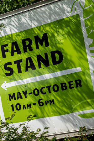 Farm stand sign and hours of local farmers market on side of green and white metal truckのeditorial素材