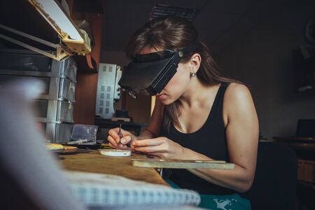 Jeweller works withl handmade jewellery at the deskの写真素材