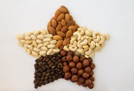 Assorted nuts in a star peanuts almonds hazelnuts pine nuts cashews on a white background