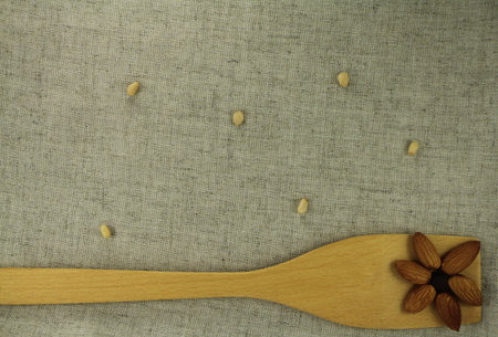 Abstract view of a wooden shovel with almonds on a background of natural fabricsの写真素材