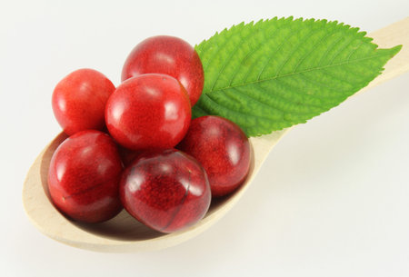 Abstract view cherry in a wooden spoon on a white background