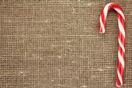 Candy Cane on a gray background of natural fabricの写真素材