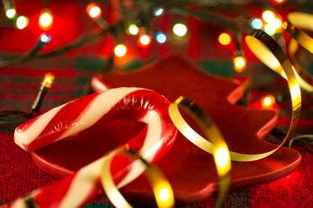 Candy Cane on a background of Christmas tablecloths and Christmas garlandsの写真素材