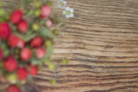 Blurred background wild strawberries on the wooden basisの写真素材
