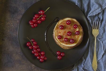 Pancakes decorated with berries and branches of red currantの写真素材