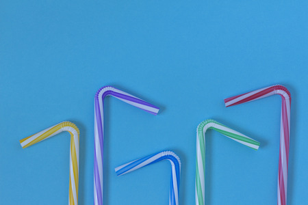 Creative view of colorful drinking straws  on a blue background. Conceptual image of summer. Minimalism. Abstraction. Top view.の写真素材