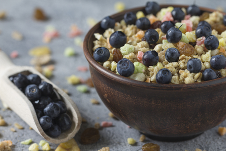 Muesli with dried fruits in a ceramic plate for breakfast on a gray uneven background.の写真素材