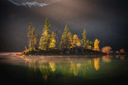 Photo Eibsee in the municipality of Grainau with the Wetterstein Mountains, forest and the Zugspitze at sunset. The Eibsee is a popular destination in Bavaria below the Zugspitze.の写真素材