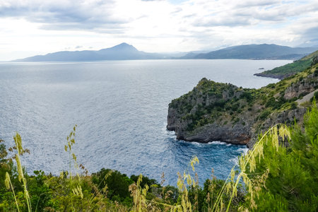 Amazing tropical panoramic view of turquoise bay, sandy beach, green mountains and plants, blue sky,...