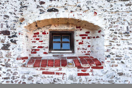 Old stone wall with old window. Cracked stone wall background. Old brick wall background. High quality photoの写真素材