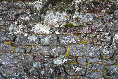Old stone wall, structure. old broken stones, cement joints close-up. crumble with age. construction, repair. concept of destruction, decline. High quality photoの写真素材