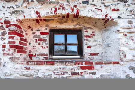 Old stone wall with old window. Cracked stone wall background. Old brick wall background. High quality photoの写真素材