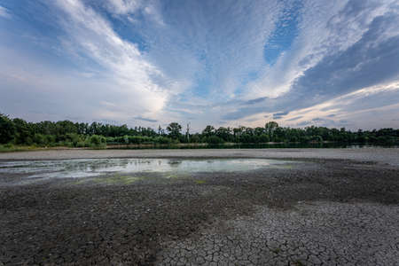 Dry lake in Bavaria Germany. Drought and climate change, landscape of cracked earth after lake has dried up in summer. Water crisis an impact of global warming.の写真素材