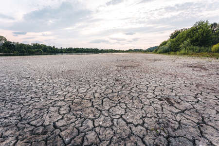 Dry lake in Bavaria Germany. Drought and climate change, landscape of cracked earth after lake has dried up in summer. Water crisis an impact of global warming.の写真素材
