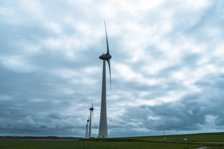 Wind turbines in the field under a cloudy sky in the Netherlands.の写真素材