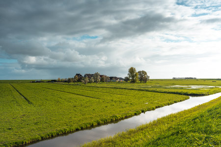 Panoramic view of a green meadow and a village in the Netherlandsの写真素材