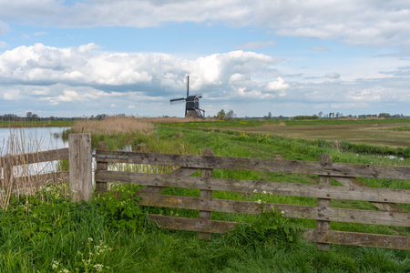 Old windmill in Kinderdijk, Netherlands with wooden fence.の写真素材