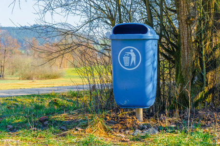 Blue recycling bin on the side of a road in the countryside.の写真素材