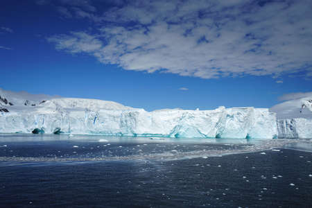 This is summer in Pleneau Island, Antarctic Peninsula. There are penguins, whales, icebergs, ice floes, glaciers, oceans, radioactive clouds and sunlight.の写真素材