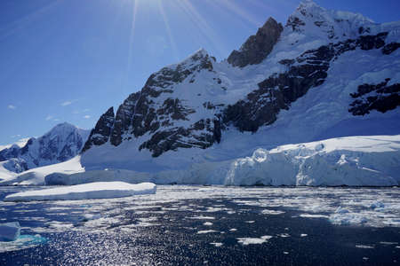 This is summer in Pleneau Island, Antarctic Peninsula. There are penguins, whales, icebergs, ice floes, glaciers, oceans, radioactive clouds and sunlight.の写真素材