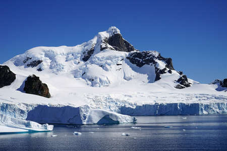 This is summer in Pleneau Island, Antarctic Peninsula. There are penguins, whales, icebergs, ice floes, glaciers, oceans, radioactive clouds and sunlight.の写真素材