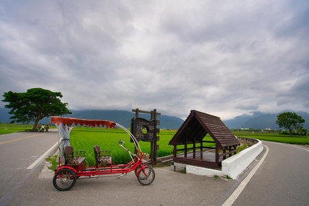 The Red tricycle and the roadside tree are the features of the attraction. Hualien County, Taiwan is a very popular place for leisure travel.の写真素材