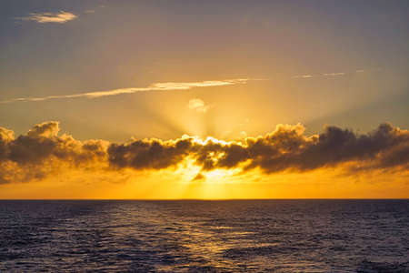 The sunlight appeared and disappeared from time to time between the clouds. The haze is very spectacular. The sunset seen from the boat. North Pacific Ocean, June, 2019.の写真素材