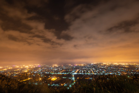 Hazy and dreamy night view of the city. The orange glow of the fog. A night view of the city shrouded in clouds. New Taipei, Taiwanの写真素材