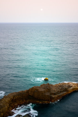 Landscape of blue sea, mountains and textured rocks. Hazy dreamy sky. Longdong is a paradise for viewing sea views in the north of Taiwan.の写真素材
