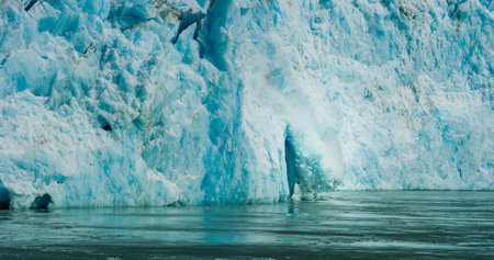 Spectacular glacier calving. Ice cubes fell into the water like an explosion. Rocks, Ice, Rivers, Forests and Mountains: The Summer Scenery of Alaska.の写真素材