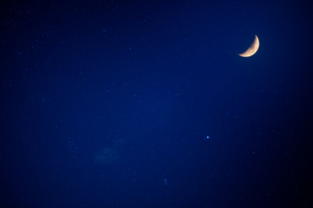 There are moon and stars in the blue sky. Slow exposure photography. Clear night sky in summer, New...