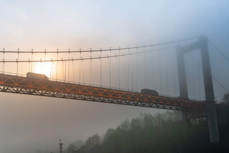 A bridge in Chongqing is shrouded in fog, a tranquil scene that captures the city's mysterious...