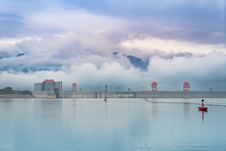 Panoramic view of the Three Gorges Dam, the largest hydroelectric power plant in the world. The sky is blue and clear and the sun is shining brightly.の写真素材