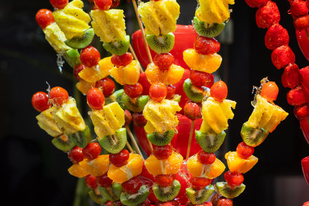 A vibrant display of fresh, smooth candied fruit skewers, a popular street food in Wuchang, China. This image captures the richness of texture and color.の写真素材