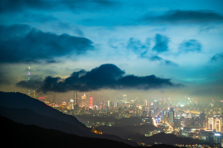 Rolling clouds and city lights enrich the night scene. Enjoy the night view of Taipei City from the mountain. Taiwanの写真素材