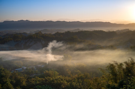 In the morning, smoke curls up from the valley and the bamboo forest is green. The Erliao tribe in Zuozhen enjoys the sunrise landscape, Tainan City, Taiwan.の写真素材