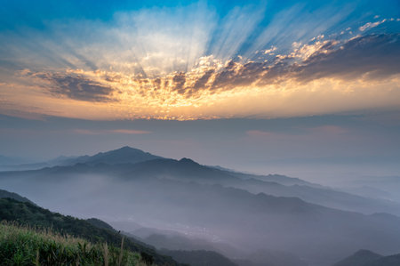 The setting sun casts a veil of mist in vibrant orange hues, creating an expansive tapestry of color...