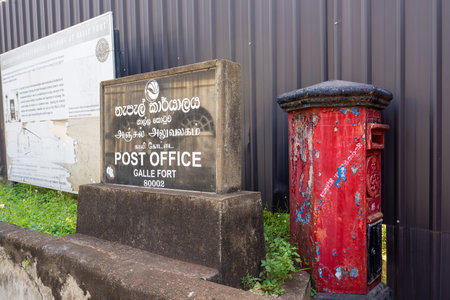 Galle, Sri Lanka - January 29, 2024: A vibrant red postbox stands on the streets of the historic...