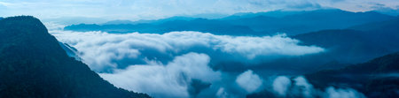 A breathtaking panoramic view of a sea of clouds below a crescent moon and a starry night sky. The silhouette of distant mountains adds depth and drama to this serene landscape. Xindian, Taiwan.の写真素材
