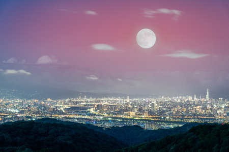A golden autumn moon hangs over the Taipei skyline, casting a warm glow on the city. The scene captures the tranquility of an autumn evening. Taipei City, Taiwan.の写真素材