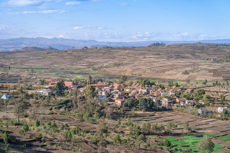 Vast farmland with green and brown patches under a clear blue sky. Rolling hills in the background. Isalo National Park, Madagascar.の写真素材