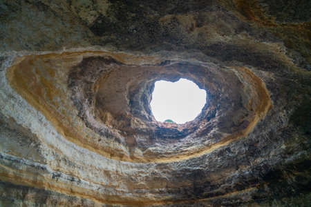 A breathtaking view of the skylight in Benagil Cave, showcasing the natural rock formations and the...