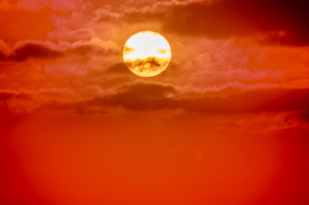 A stunning orange sunset illuminates the sky. The warm hues of the setting sun create a beautiful and serene scene. Tranquil scene at dusk.の写真素材