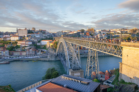 Porto, Portugal - November 10, 2024: Tourists enjoy the sunset view on the Ponte Dom Luis I Bridge,...