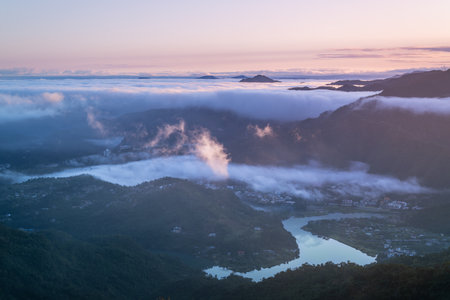 A serene spring dawn. Orange skies meet flowing white clouds.の写真素材