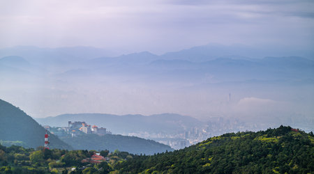 A university stands atop Datun Mountain in Taipei, Taiwan, enveloped by morning mist in spring. The tranquil scene blends academic architecture with natural beauty.の写真素材